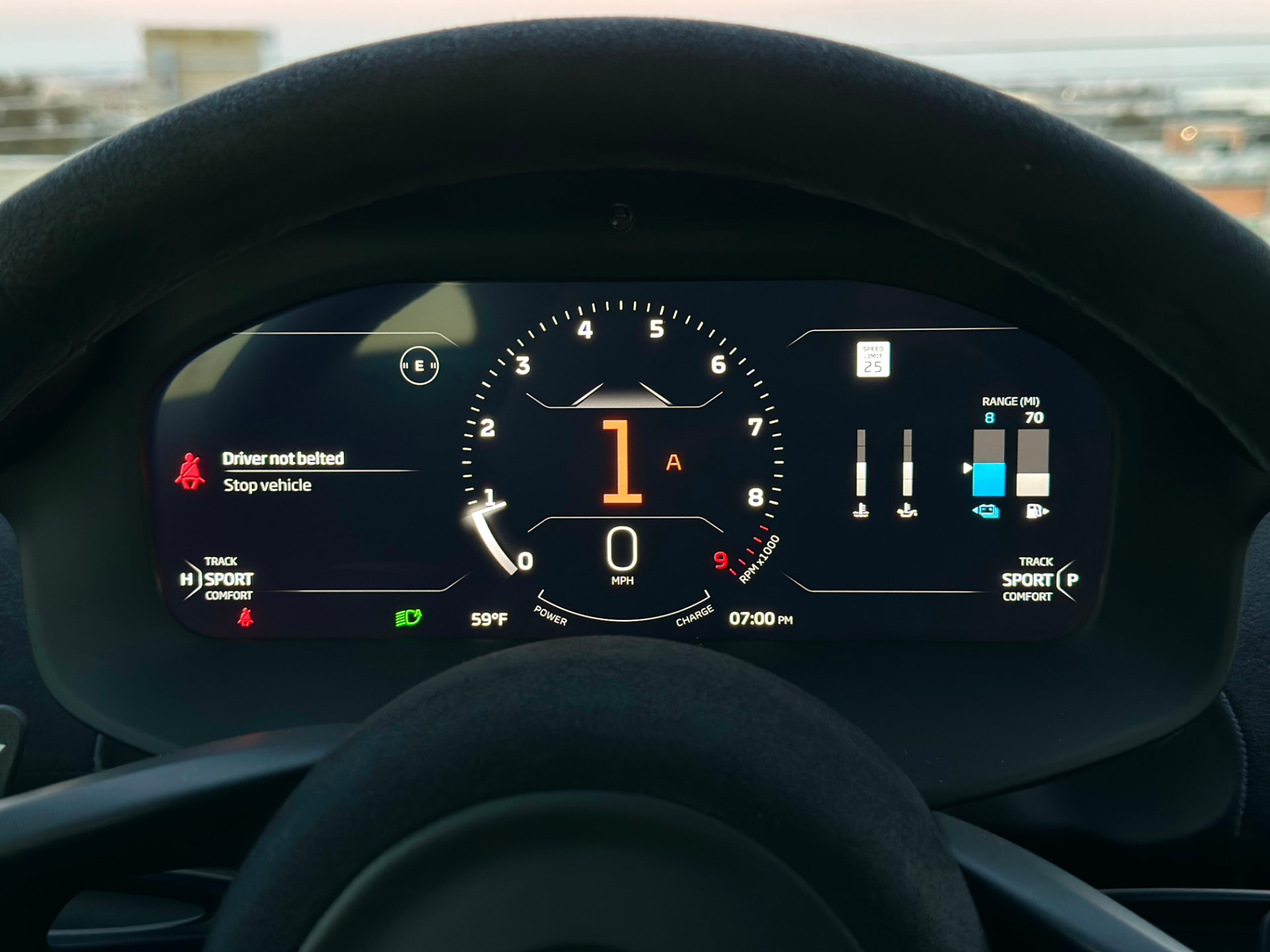 Digital instrument cluster viewed through a car's suede steering wheel