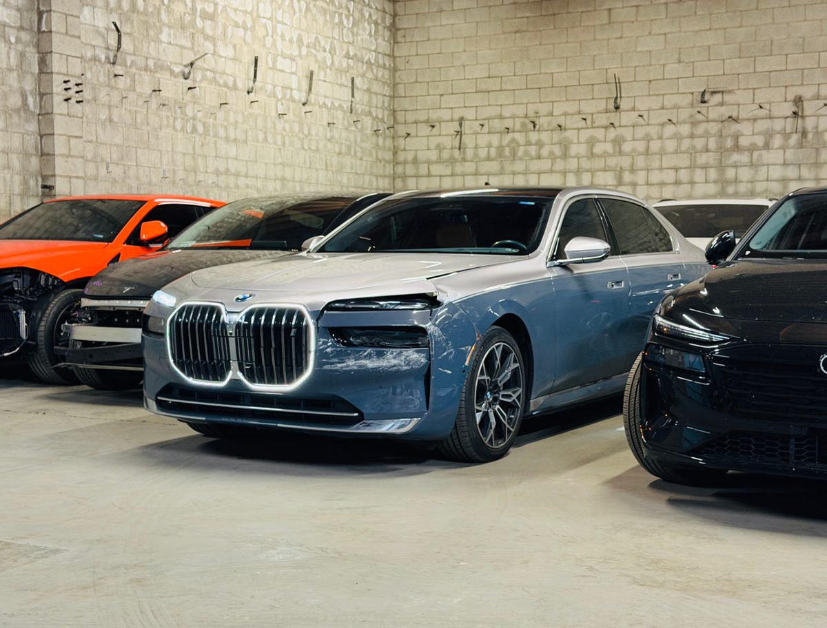 Damaged cars waiting for bodywork inside a collision repair shop
